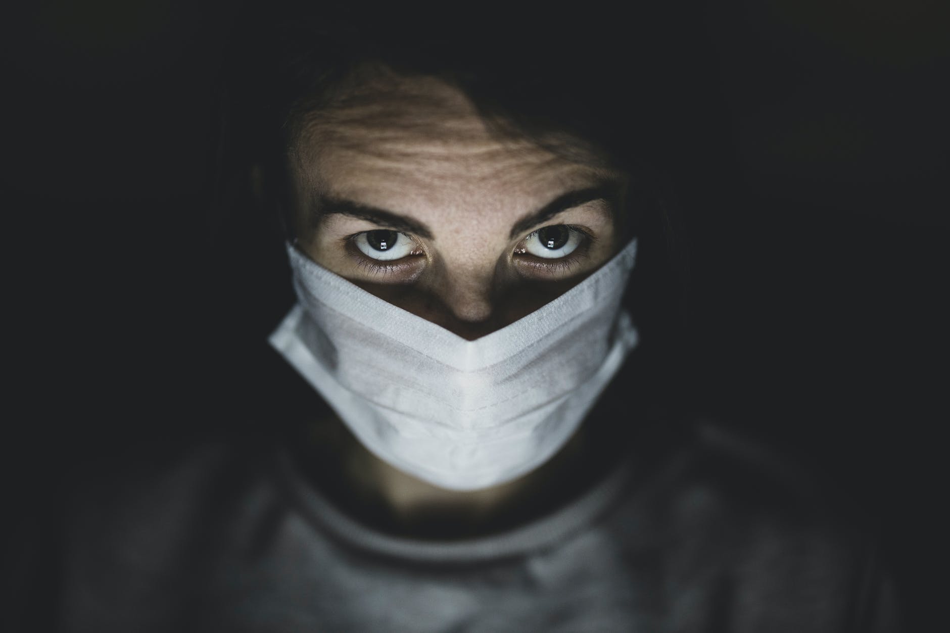 man wearing face mask in a dark room