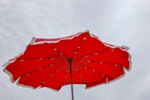 red umbrella under white sky sun poisoning