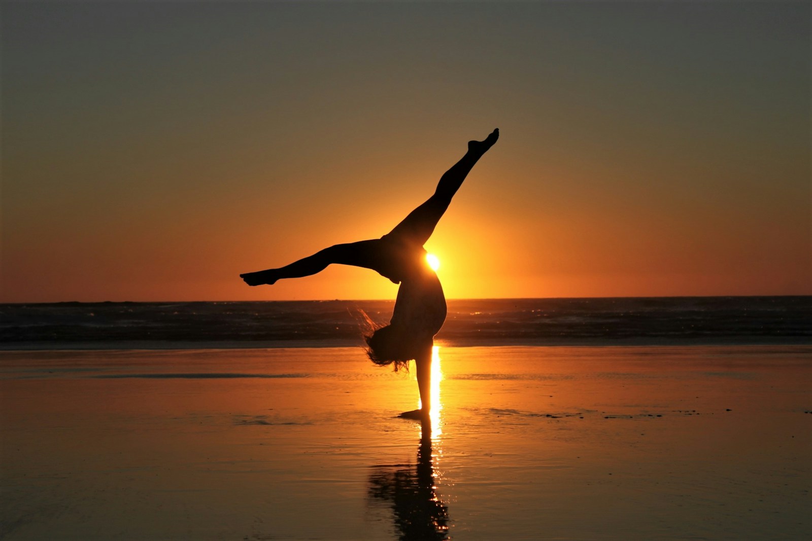 woman in white dress standing on beach during sunset